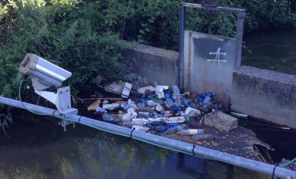 Rifiuti e bottiglie nel rio a pochi metri dal parco fluviale