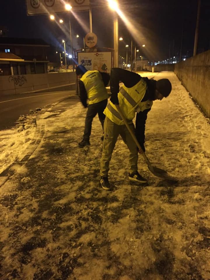 I volontari ripuliscono i marciapiedi dalla neve