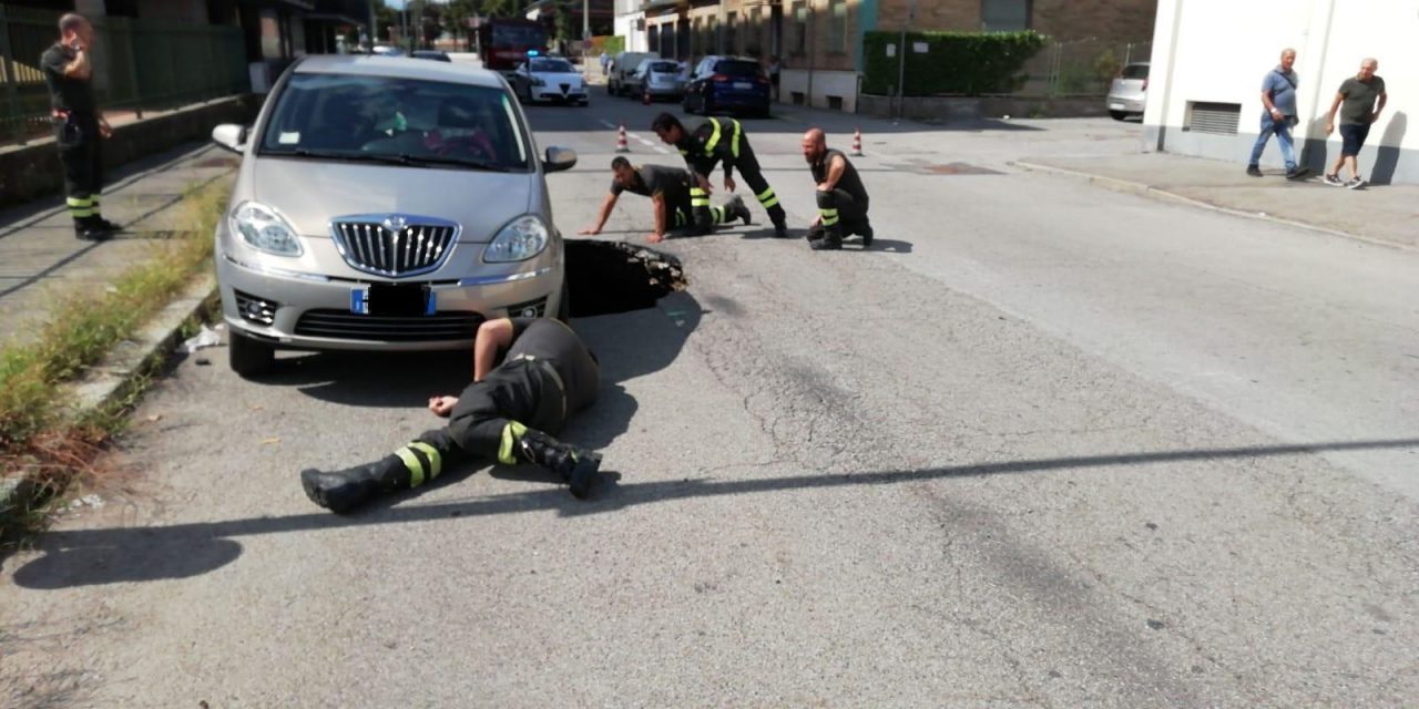 Voragine in strada sotto a un’auto
