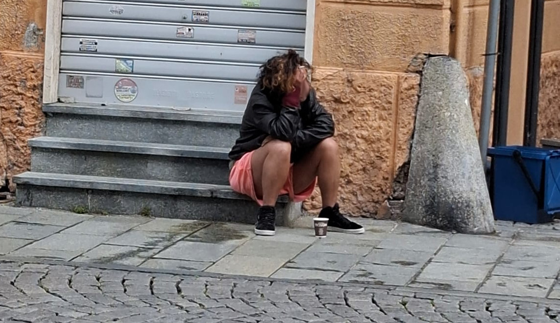 Si sdraia tra le auto (anche nuda) e fa i bisogni davanti ai negozi